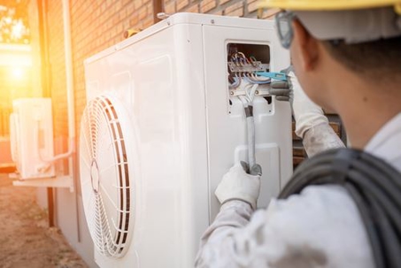 Man working on AC unit in heat