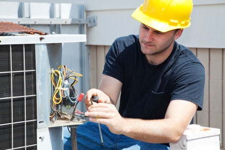 Young man working on AC machine